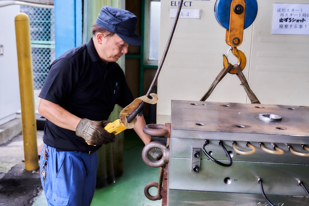 金型をクレーンで運ぶ工場スタッフ